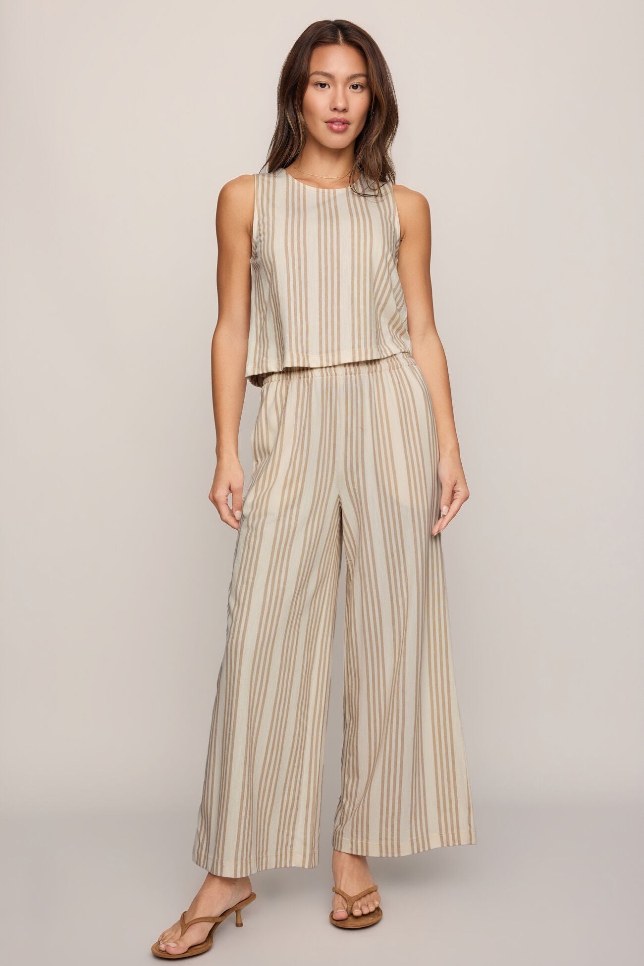 Striped knit sleeveless top with crew neck, light beige base and tan vertical stripes