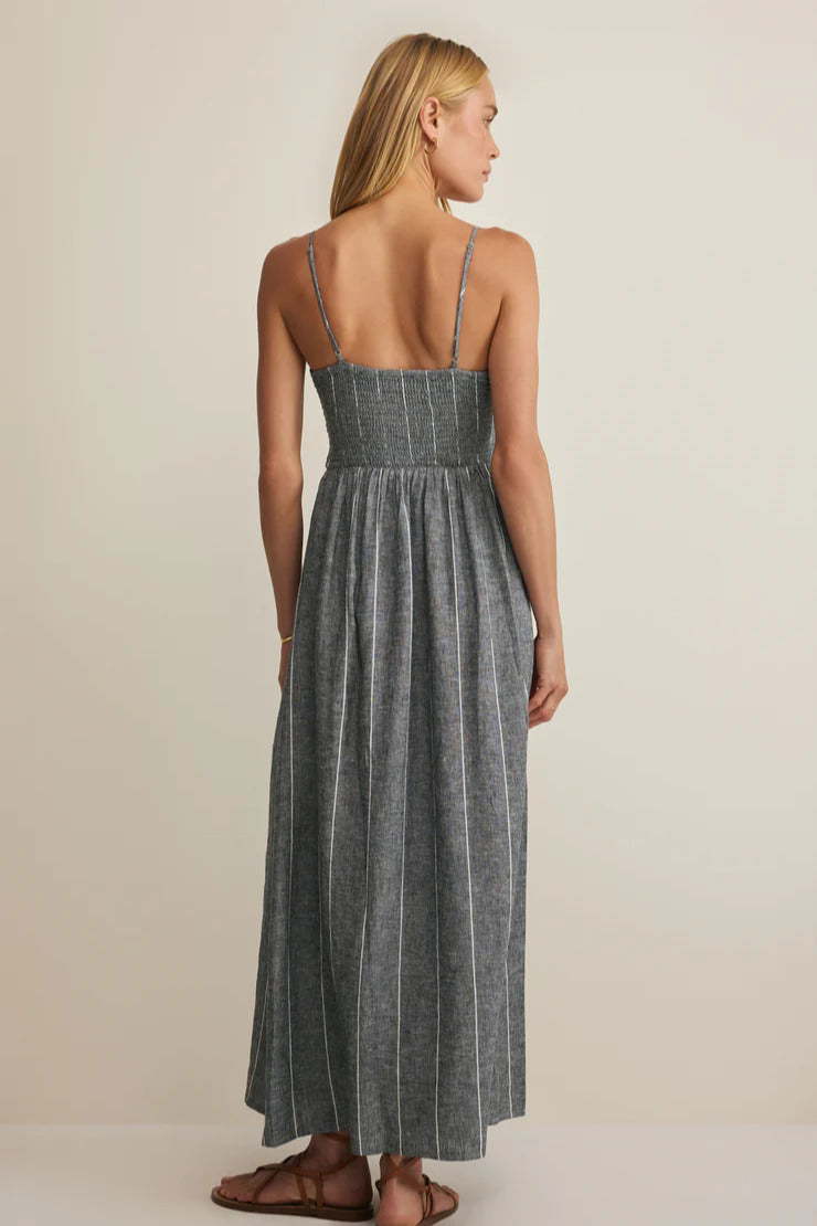 Back view of dark gray striped maxi dress with spaghetti straps and gathered waist