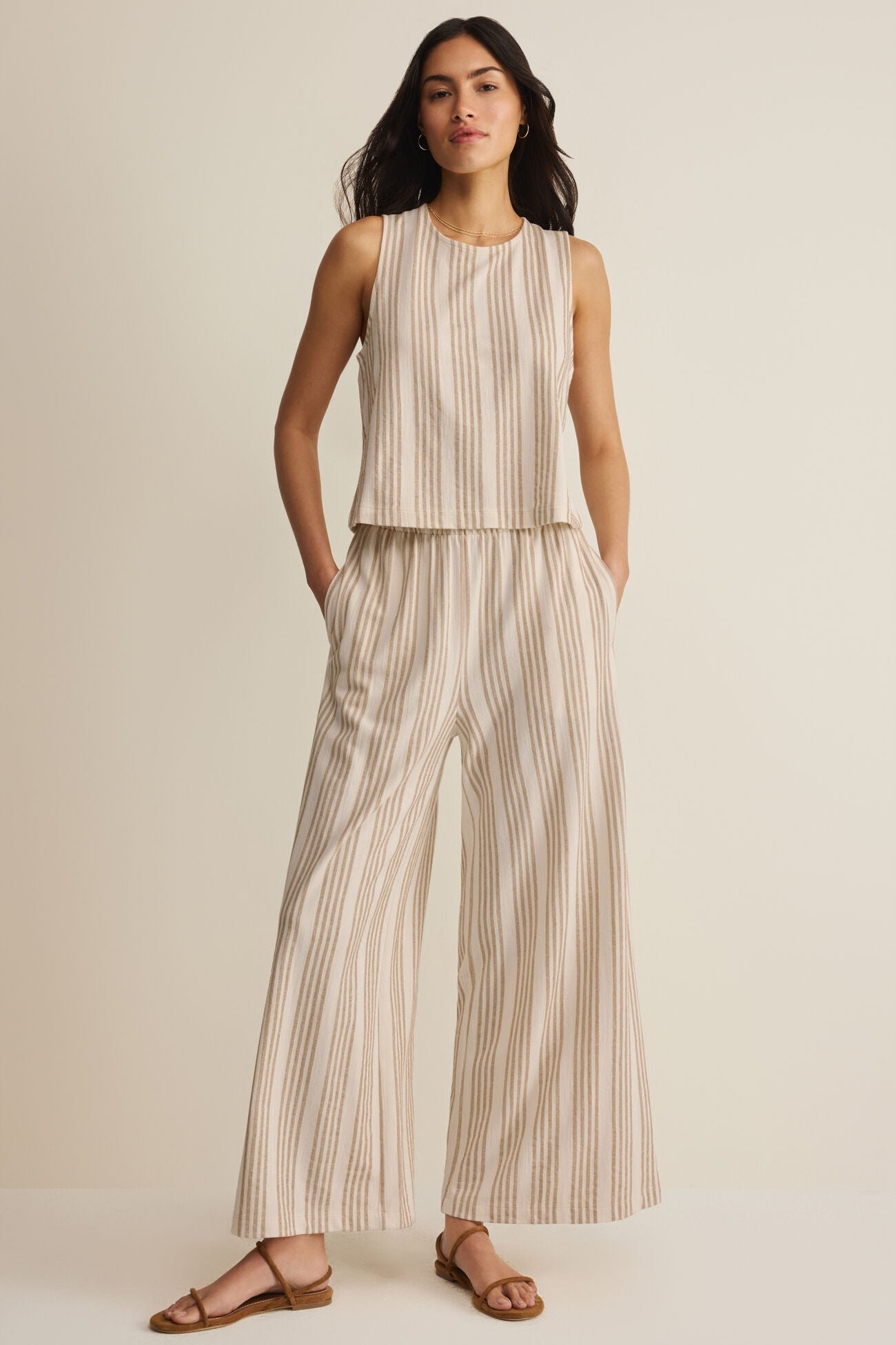Striped knit pants with elastic waist, wide-leg silhouette, light base and tan vertical stripes