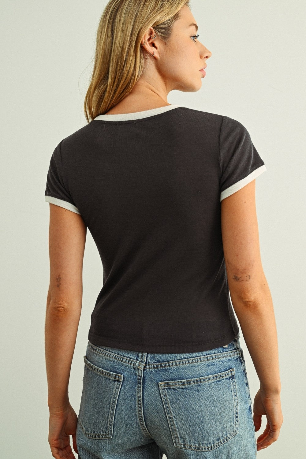 Dark short-sleeve ringer tee from back with cream collar and sleeve trim