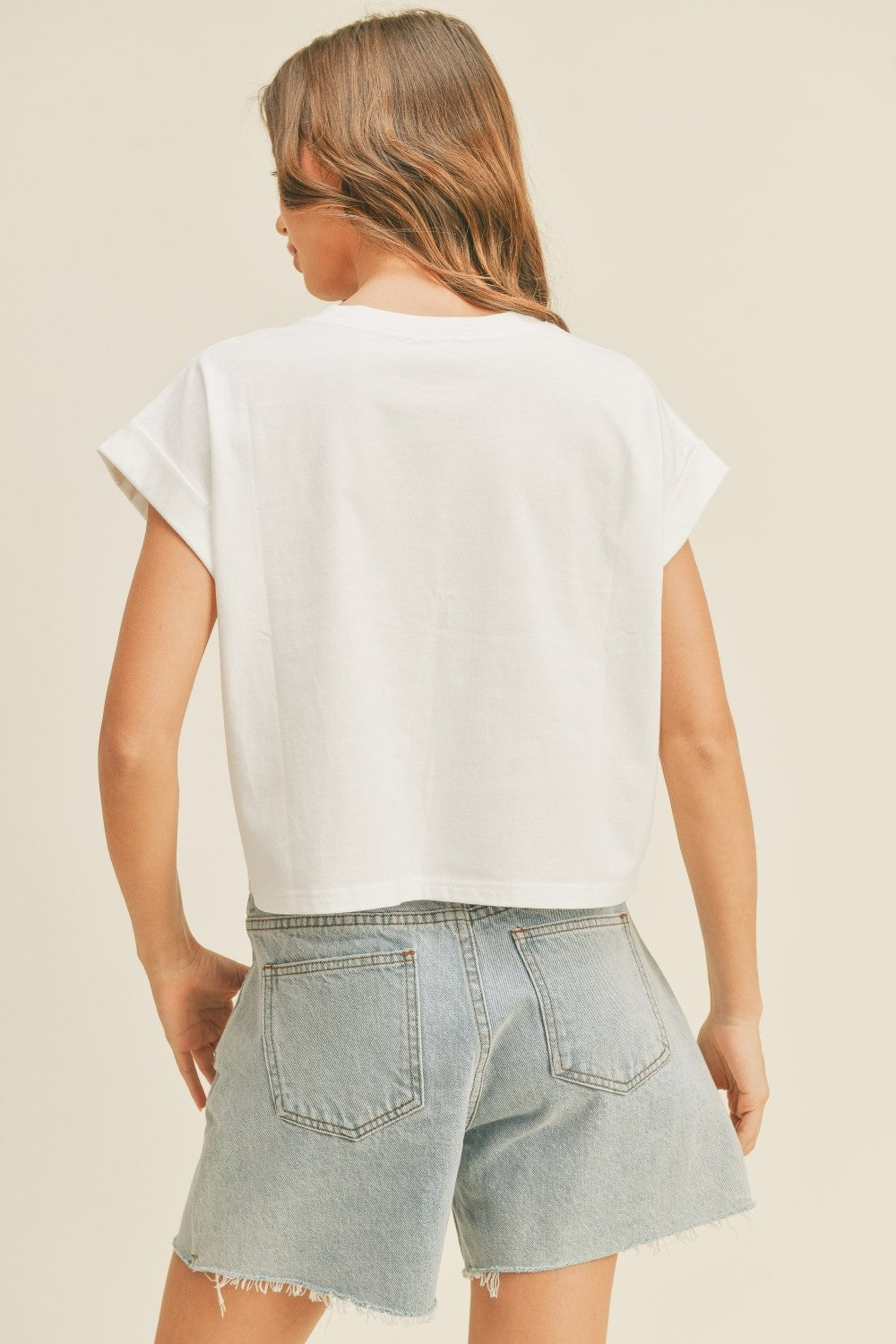 Off-white round neck cuff sleeve top, short back view with curved hem