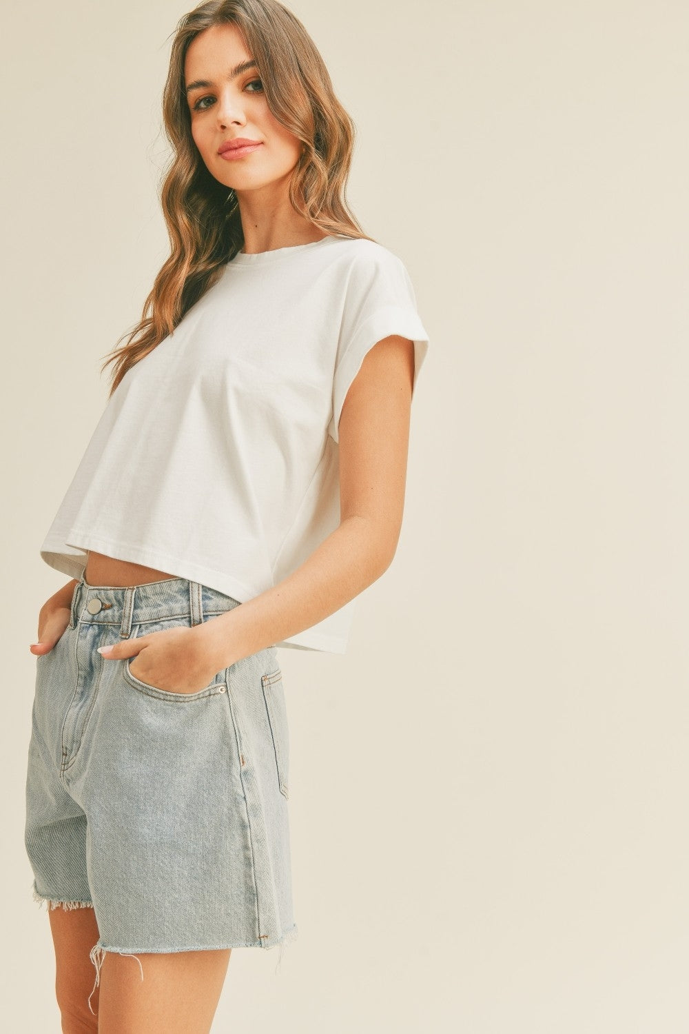 Off-white round neck cuff sleeve top, short sleeves with draped cropped front