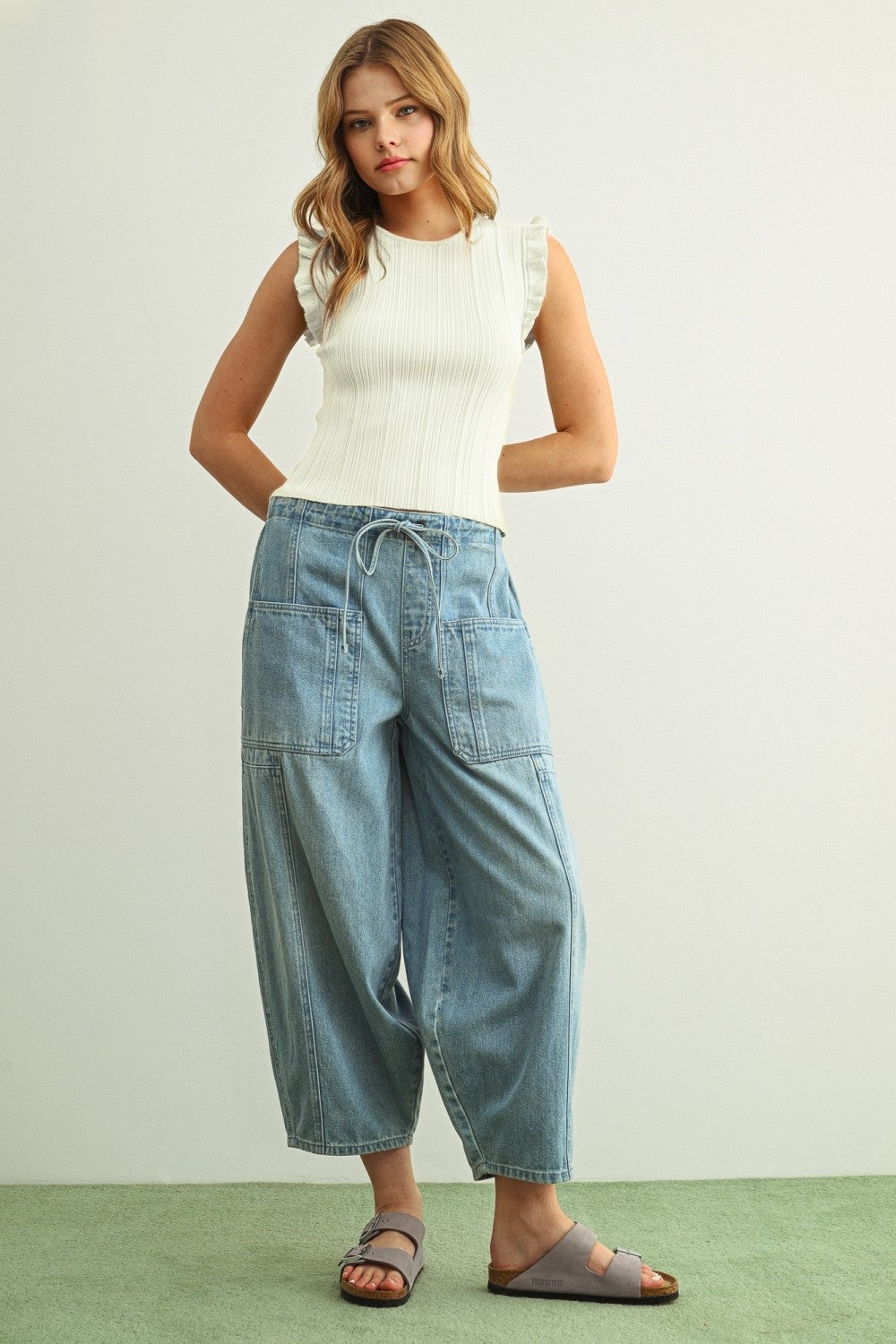 Off-white ribbed knit top with ruffle sleeves