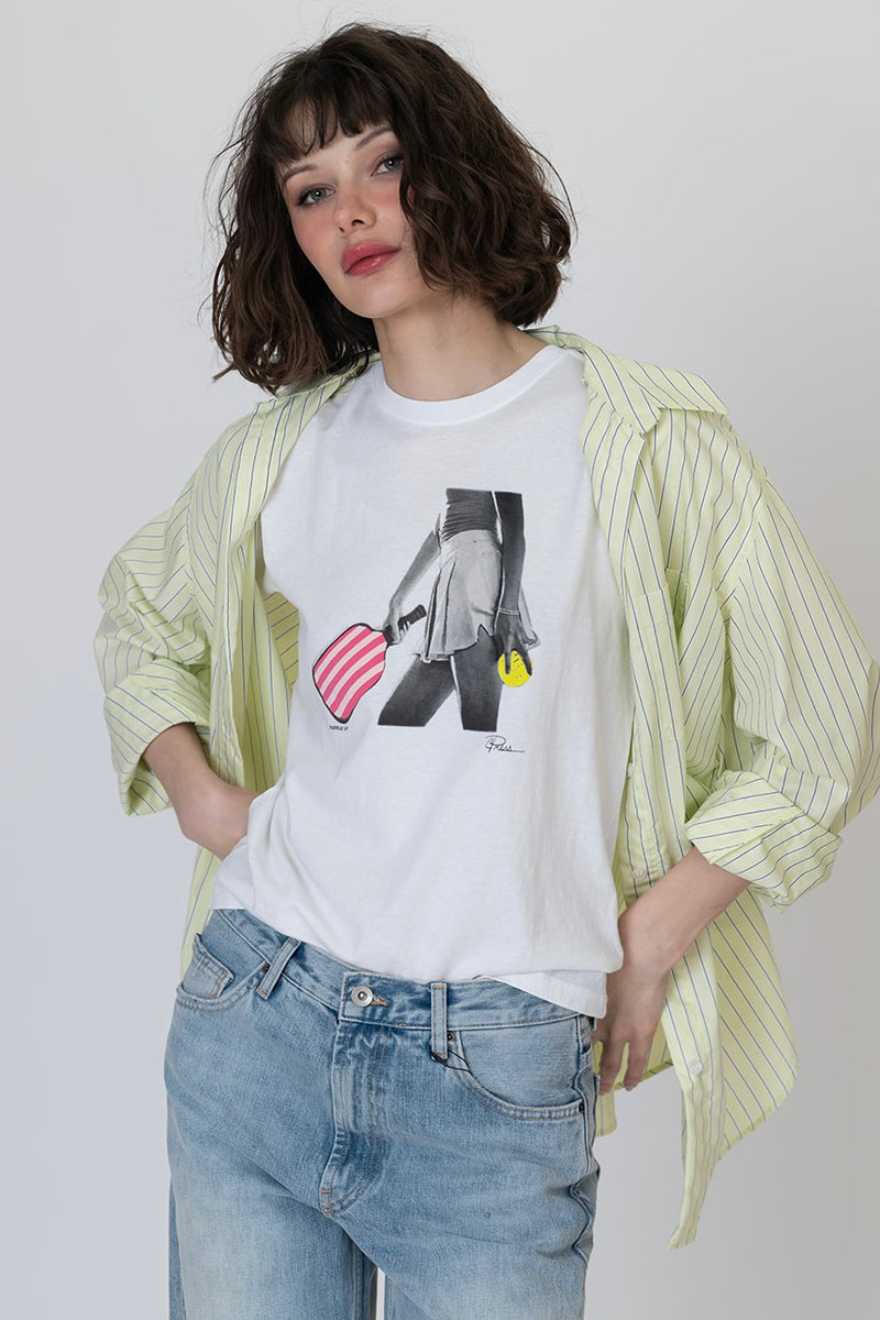 White graphic T-shirt with central black-and-gray figure, red striped heart, and yellow drop