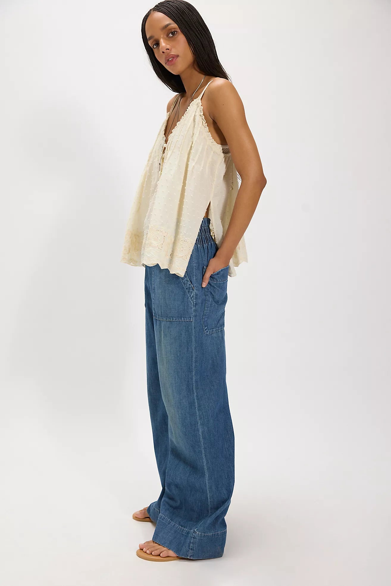 Woman wearing a beige top and cobalt breezy denim pull on blue jeans on a white background