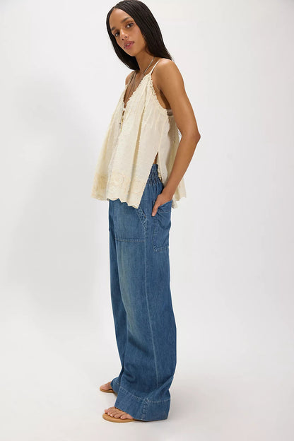 Woman wearing a beige top and cobalt breezy denim pull on blue jeans on a white background