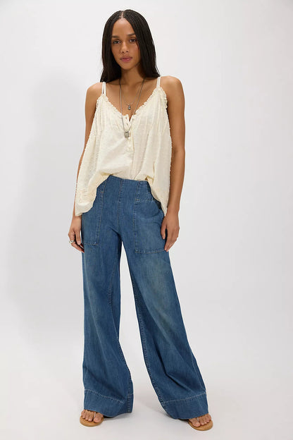 Woman wearing a beige top and cobalt breezy denim pull on blue jeans on a white background