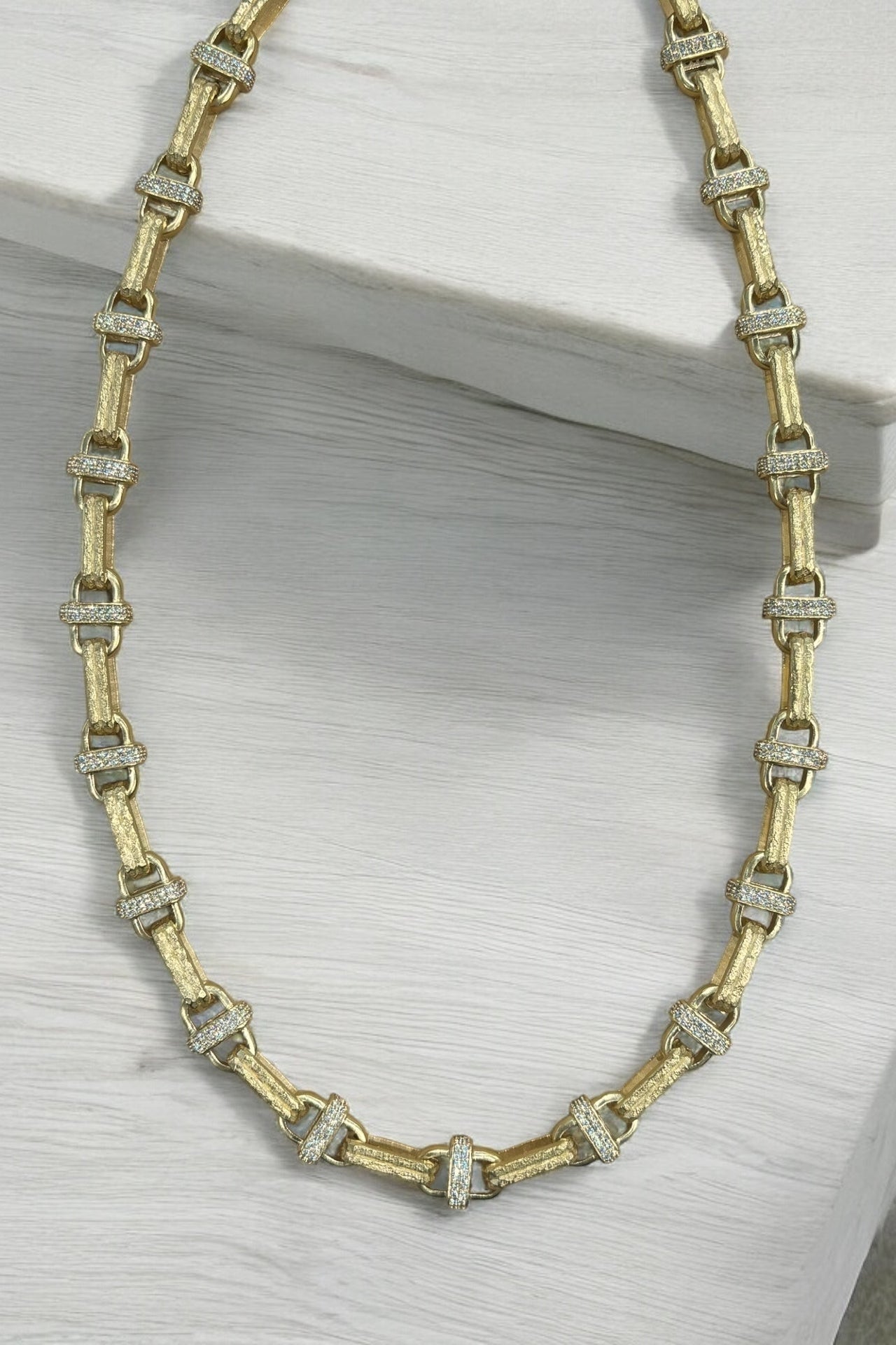 Gold-tone chain necklace with rectangular link settings and clear crystal spacers