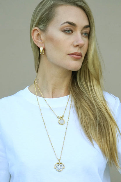 Gold spinner necklace with layered chain and round rotating pendant, clear accents