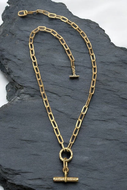 Gold toggle necklace with long oval link chain, circular toggle, and rectangular bar pendant
