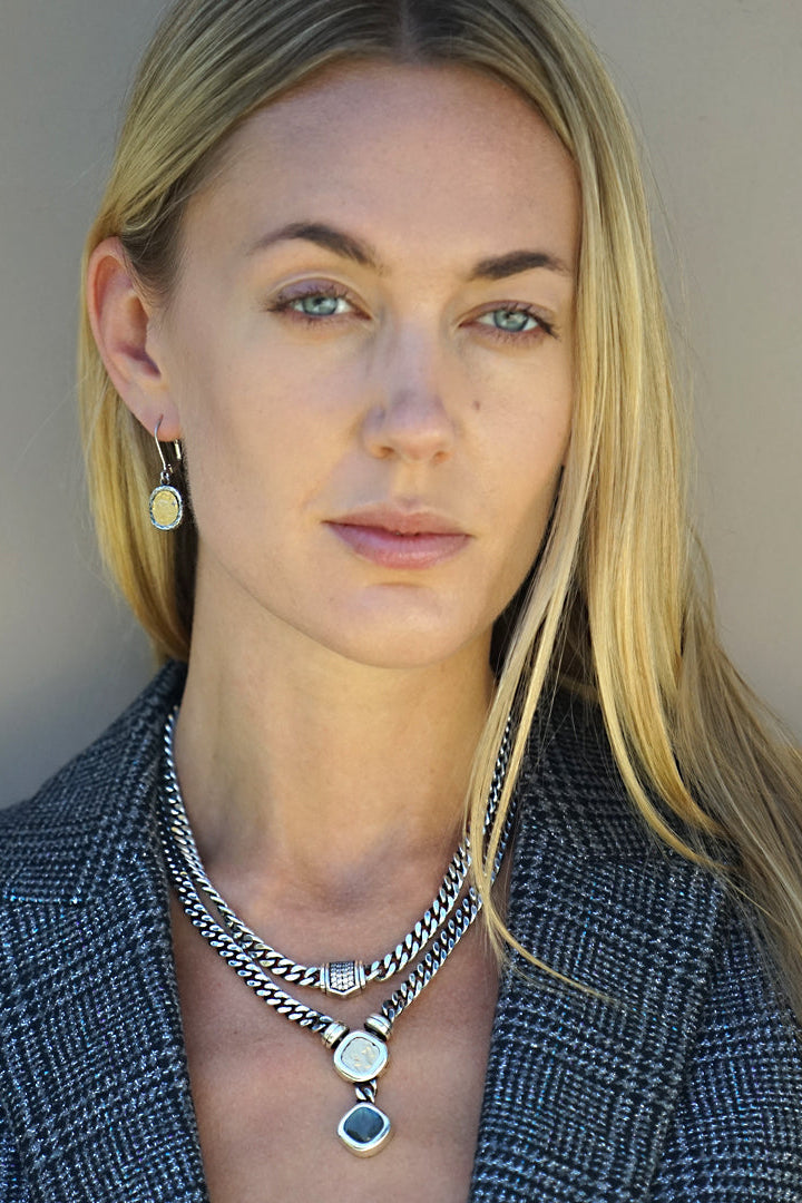 Silver curb chain necklace with rectangular crystal centerpiece, worn at neckline