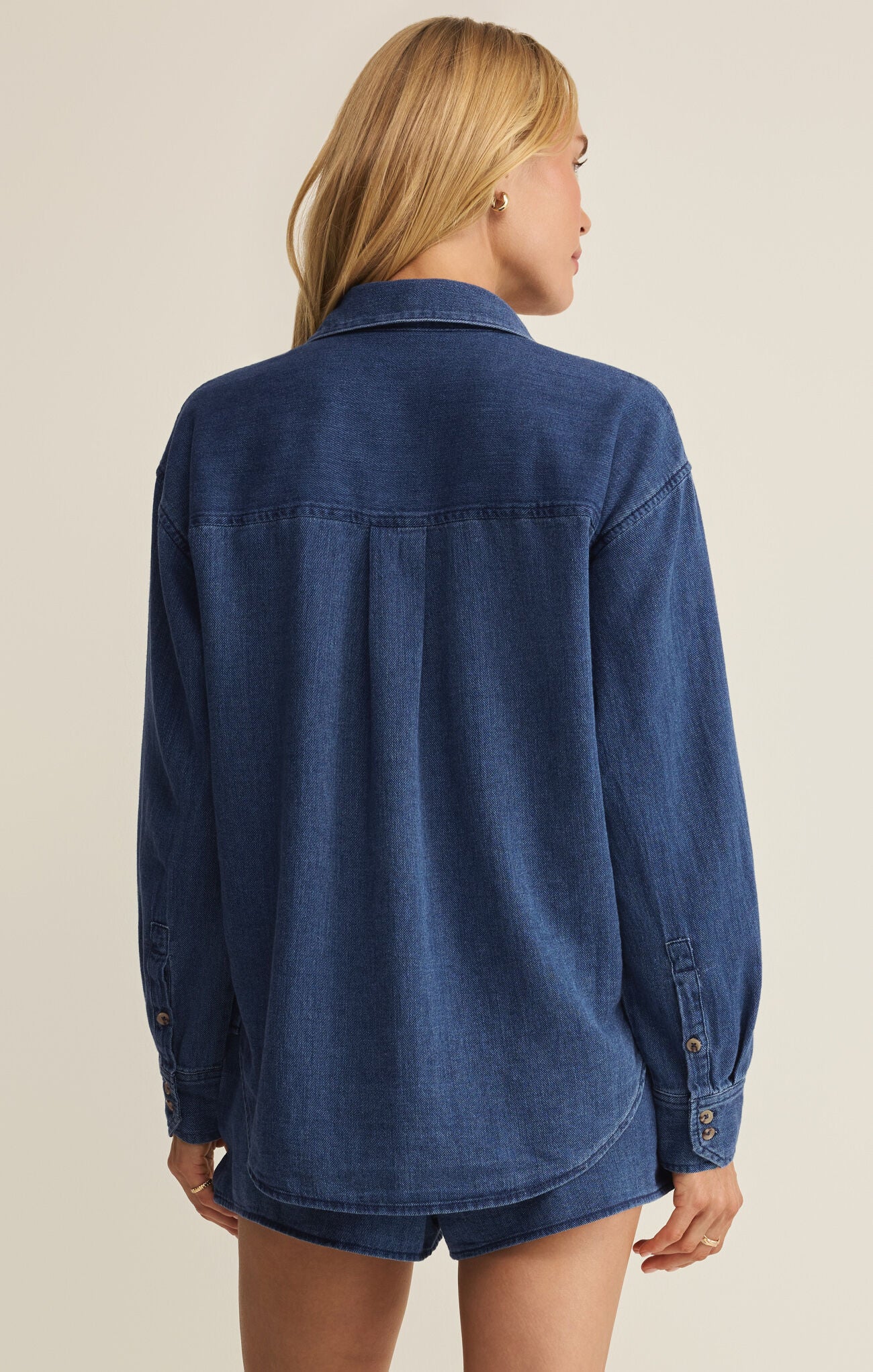 Blue twill button-up shirt back view, yoke seam and two buttoned cuffs
