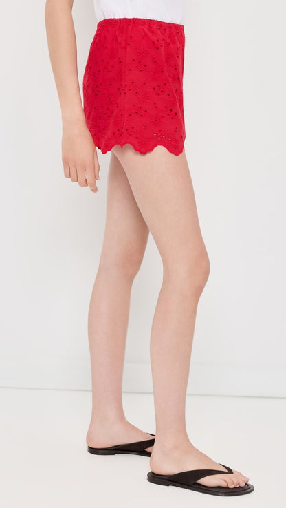 Red lace skirt worn by a person on a white background