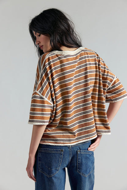 Person wearing a striped shirt and jeans against a plain background