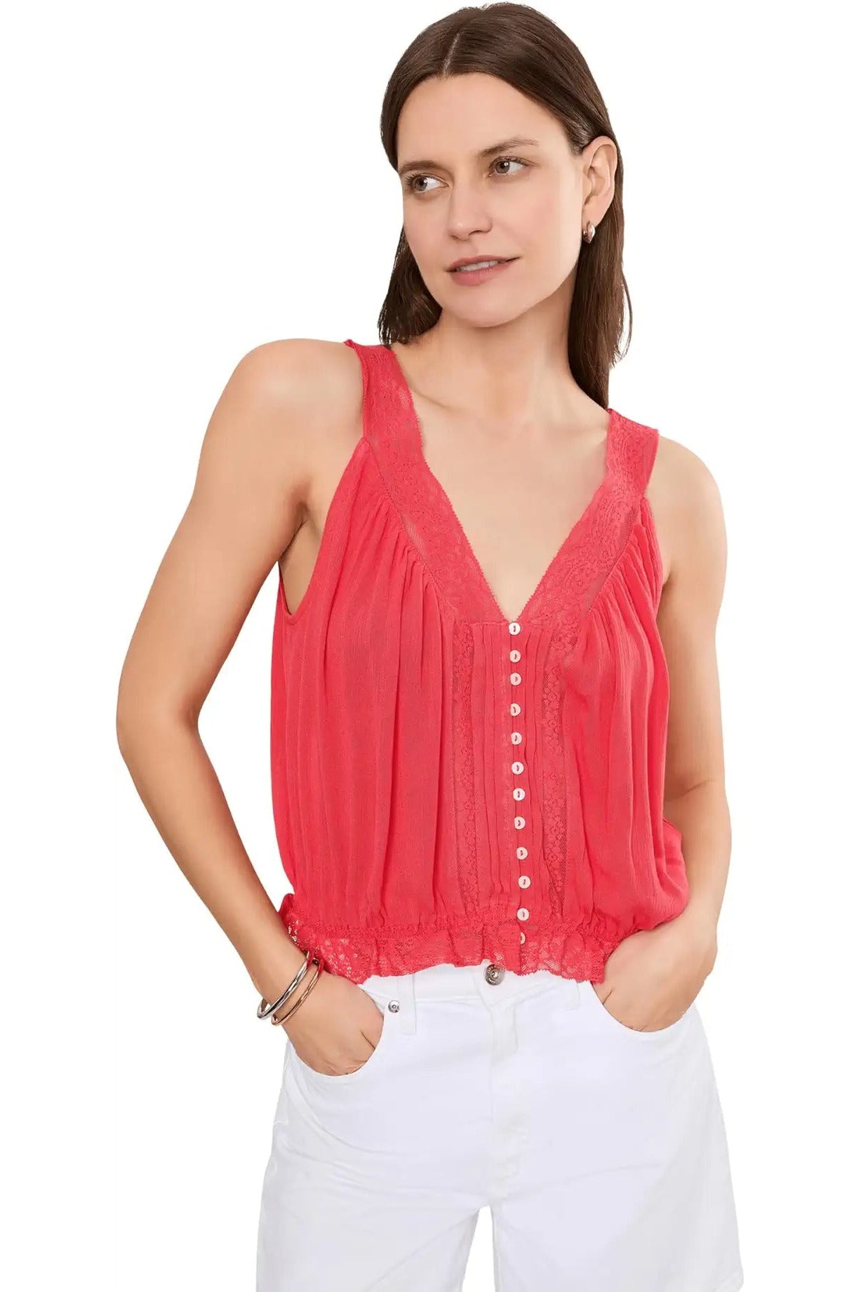 Woman wearing a coral sleeveless top with a white background