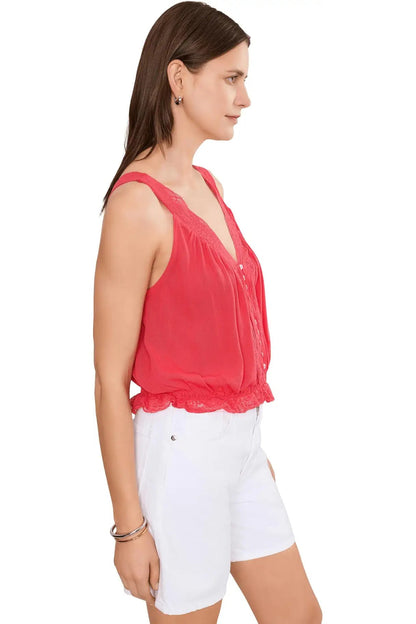 Woman wearing a red sleeveless top and white shorts on a white background
