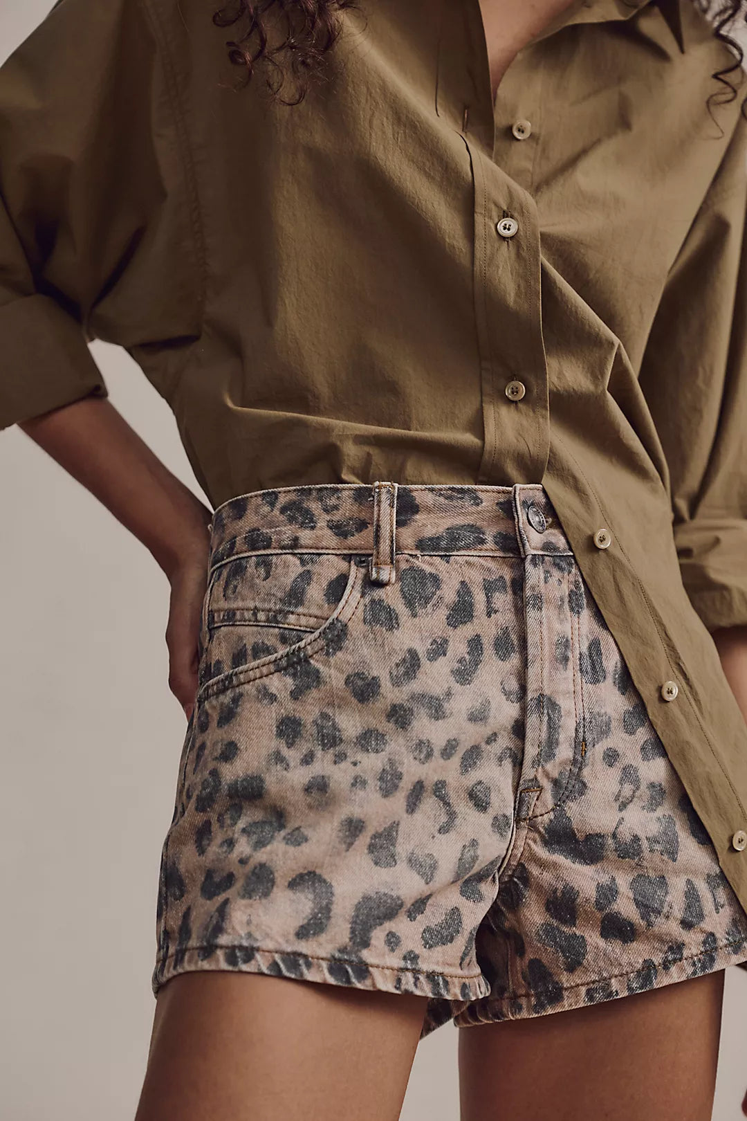 Leopard print denim shorts close-up with front button and stitched seams