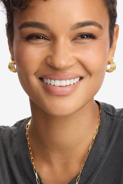 Gold 5-row hoop earrings on model, front view.