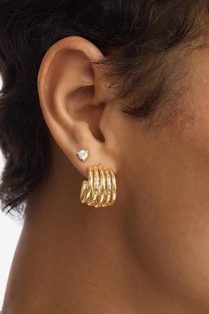 Gold 5-row hoop earrings on ear, side profile view.