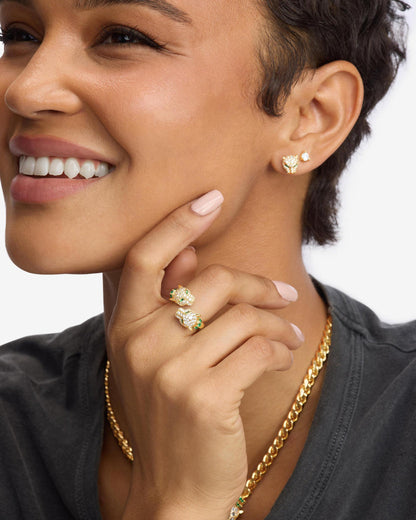 Gold pavé ring with green stones, worn on finger