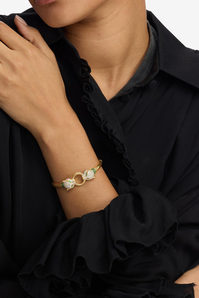Gold cuff bracelet with linked loop motif, clear crystals and green stone accents