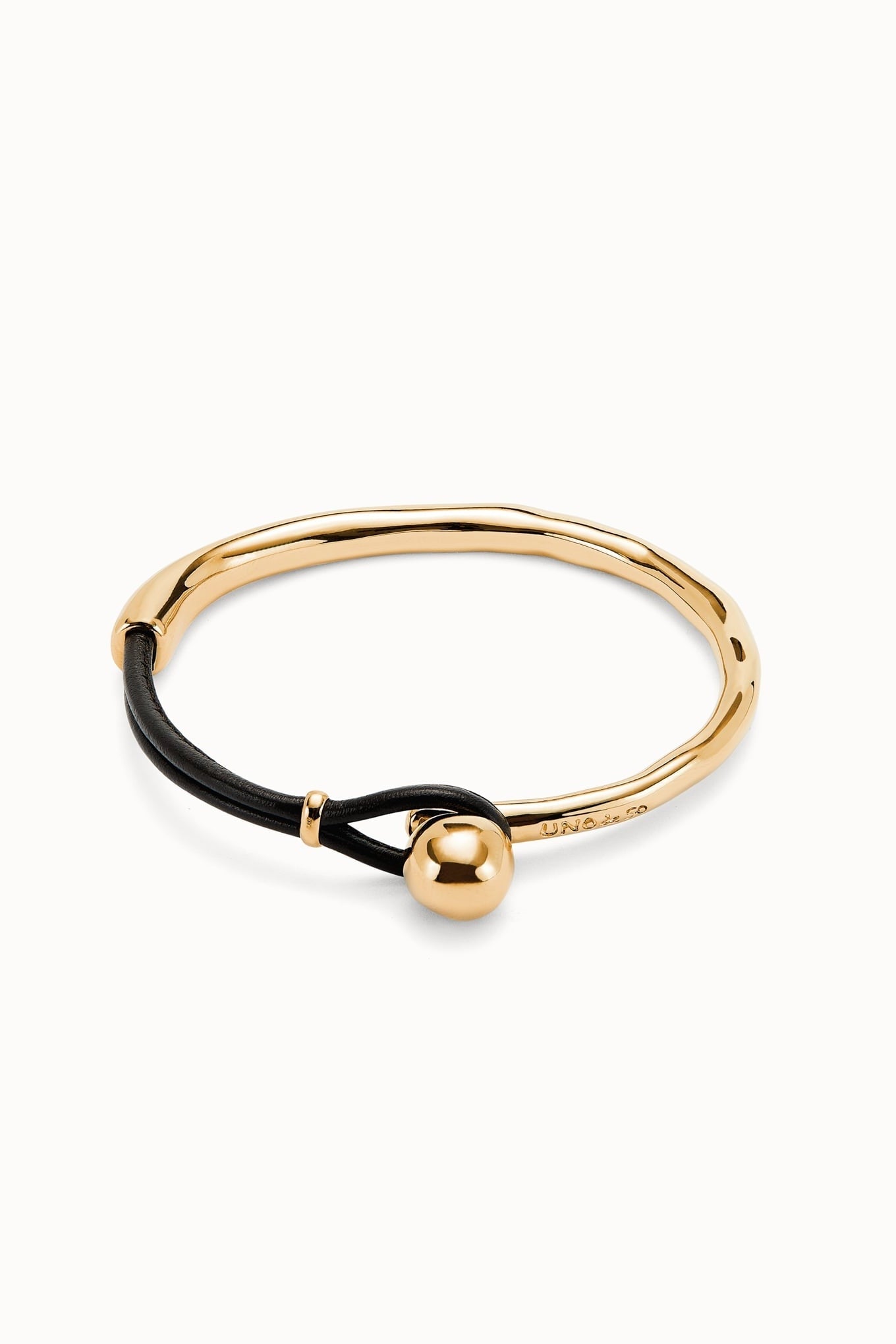 Gold-tone bracelet with black cord and gold ball charm, sleek bangle style