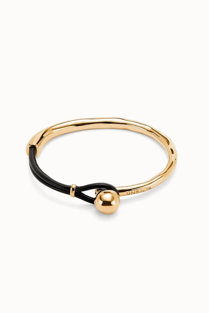 Gold-tone bracelet with black cord and gold ball charm, sleek bangle style