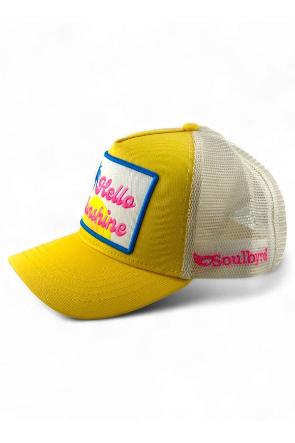 Yellow and beige cap with a colorful patch on a white background