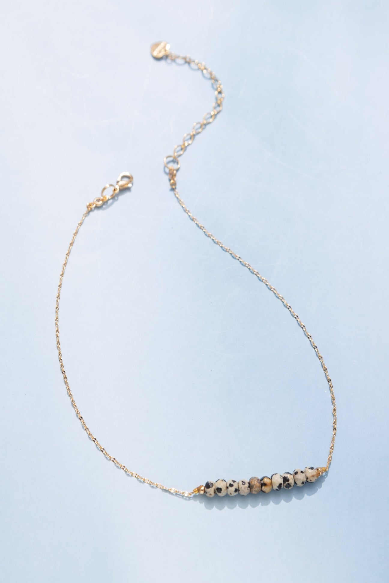 Brown single-strand beaded necklace with black spot accents and lobster clasp