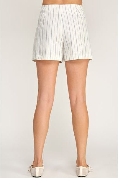 White pinstripe shorts worn by a person on a plain background