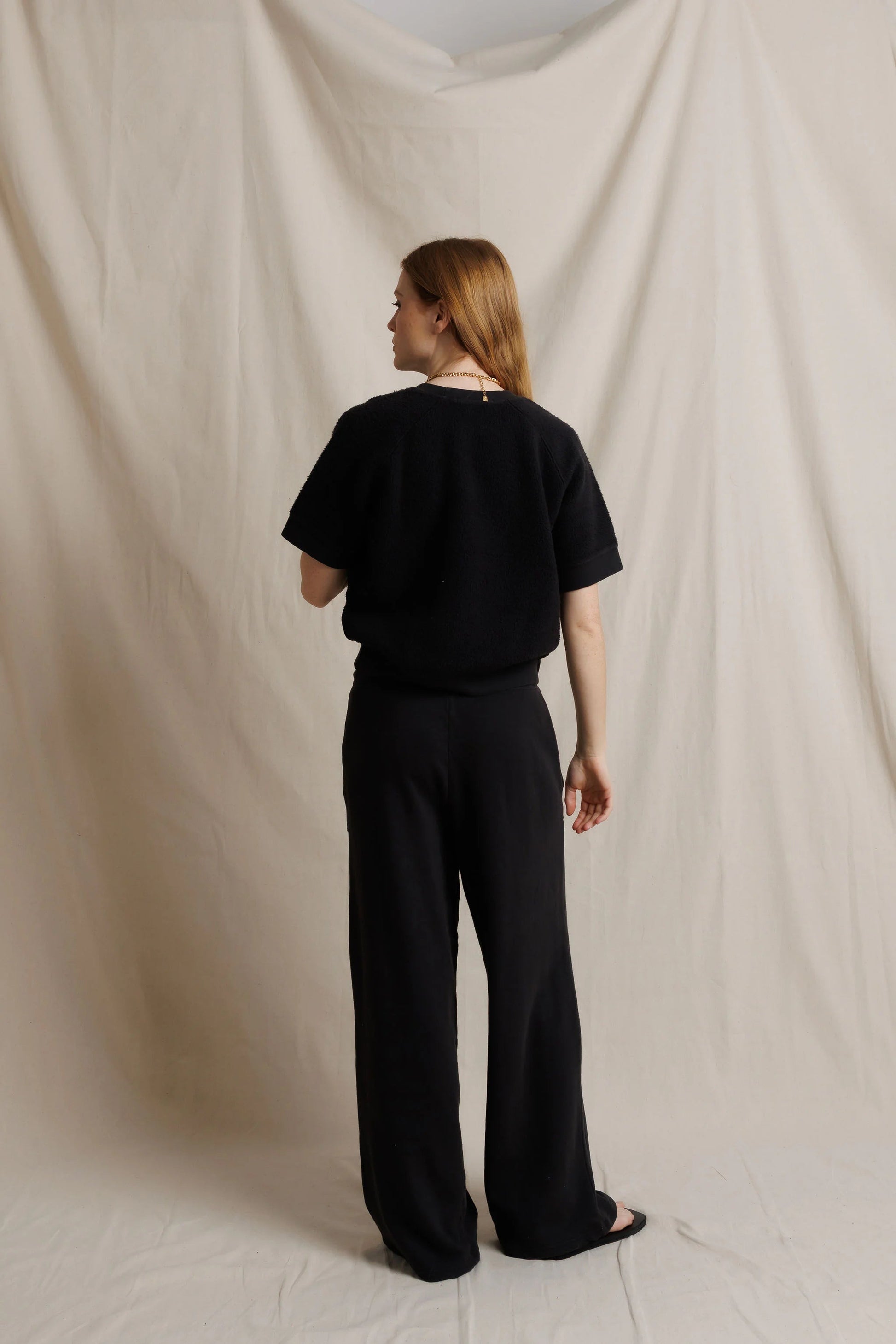 Black fleece short-sleeve sweatshirt set, back view with wide-leg pants