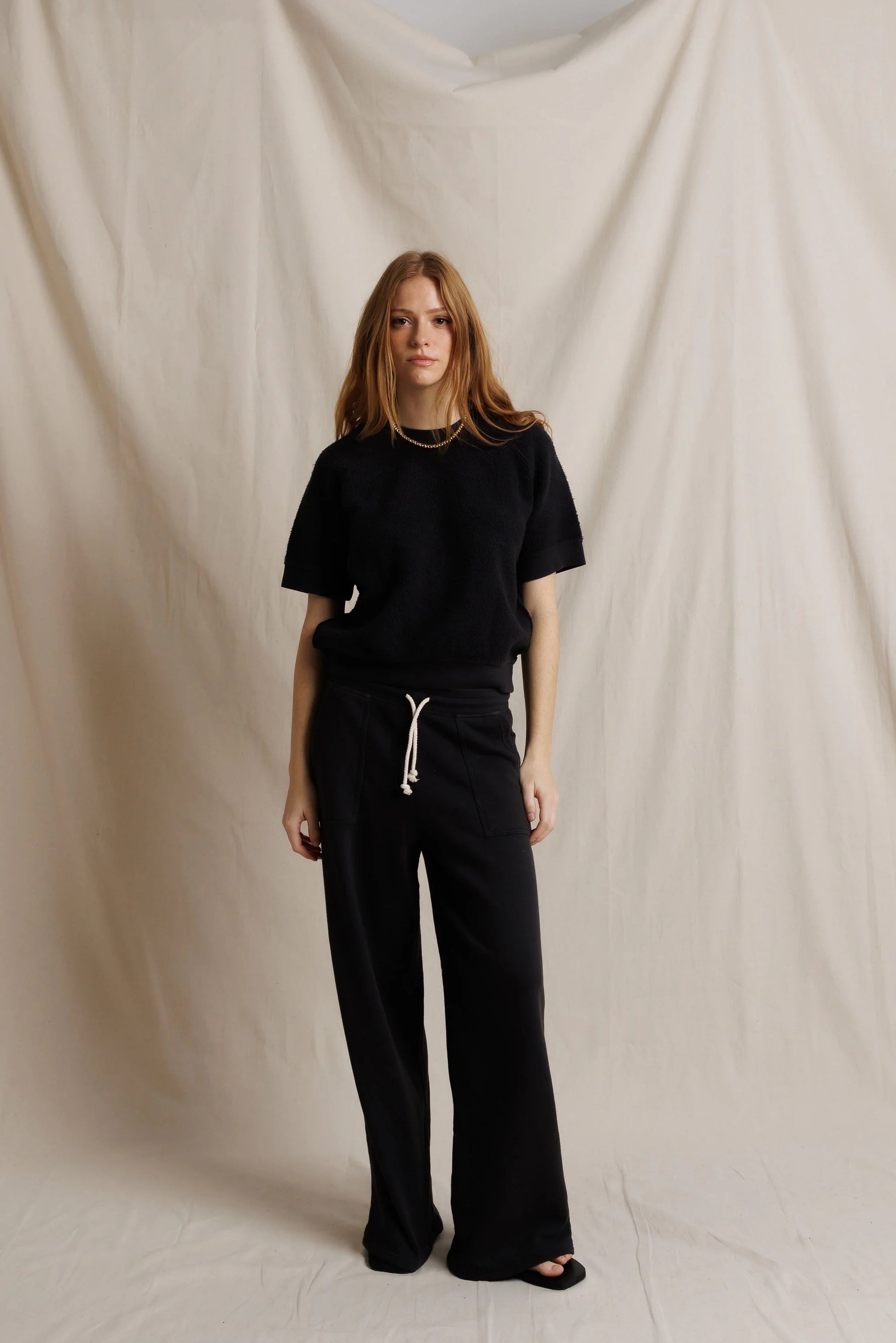 Black fleece short-sleeve sweatshirt with drawstring waist pants and visible pocket