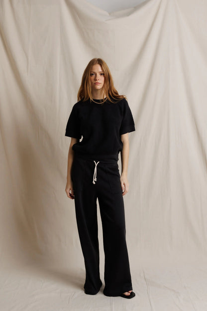Black fleece short-sleeve sweatshirt with drawstring waist pants and visible pocket