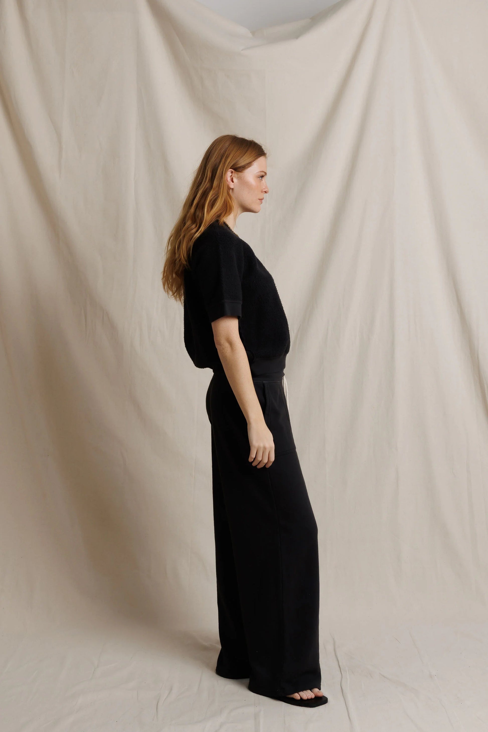 Black fleece short-sleeve sweatshirt with straight-leg pants, side view