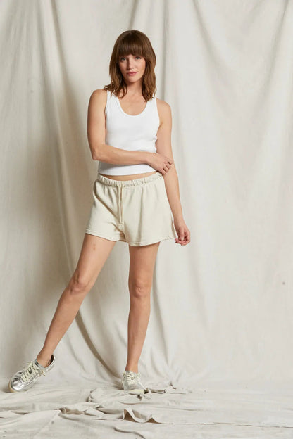 Cream fleece shorts with elastic waist and drawstring, model wearing with tank top