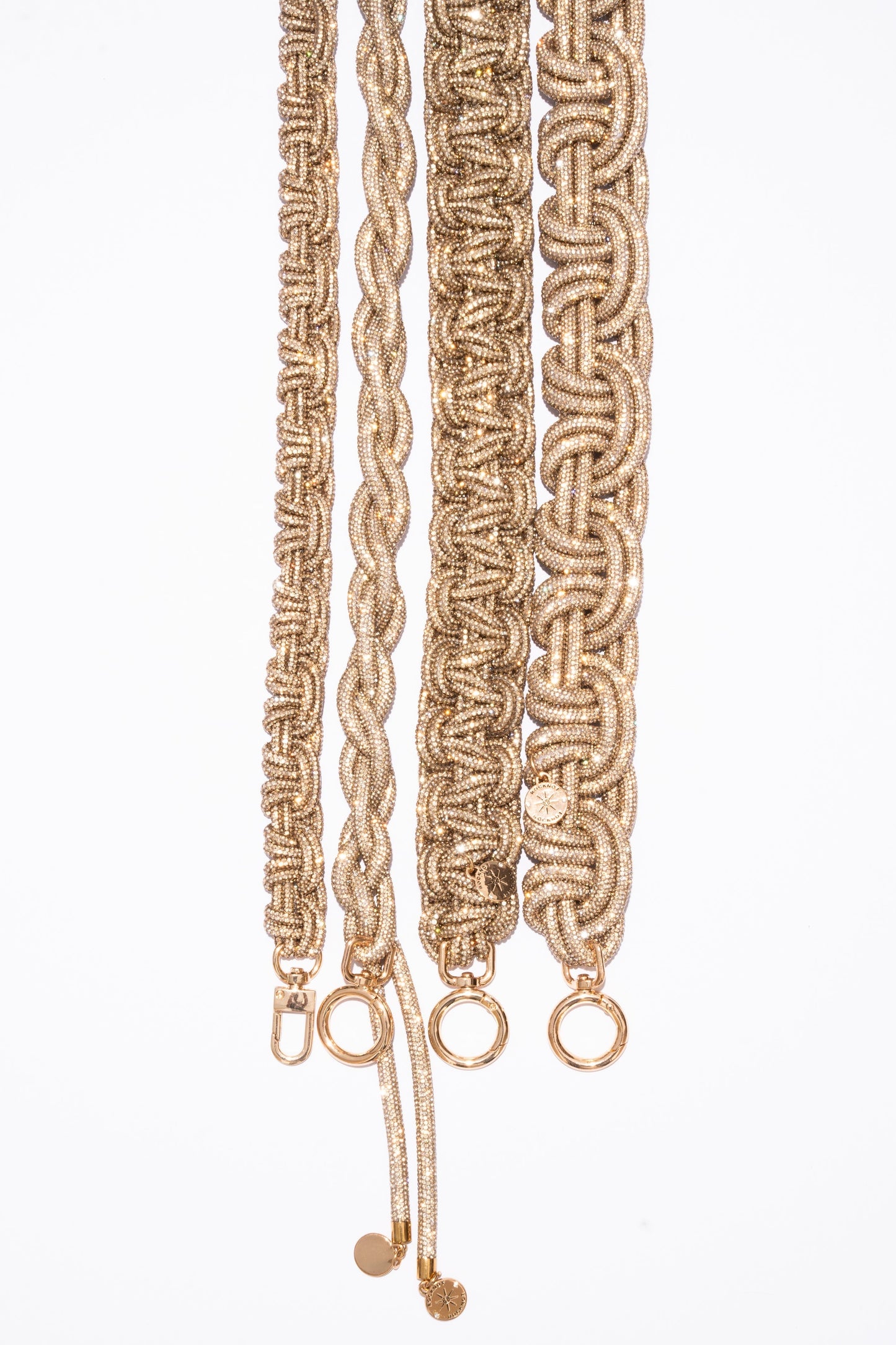 Braided champagne straps with gold hardware on a white background