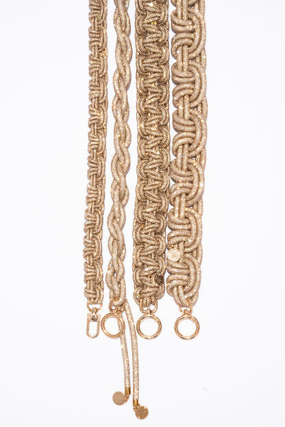 Braided champagne straps with gold hardware on a white background