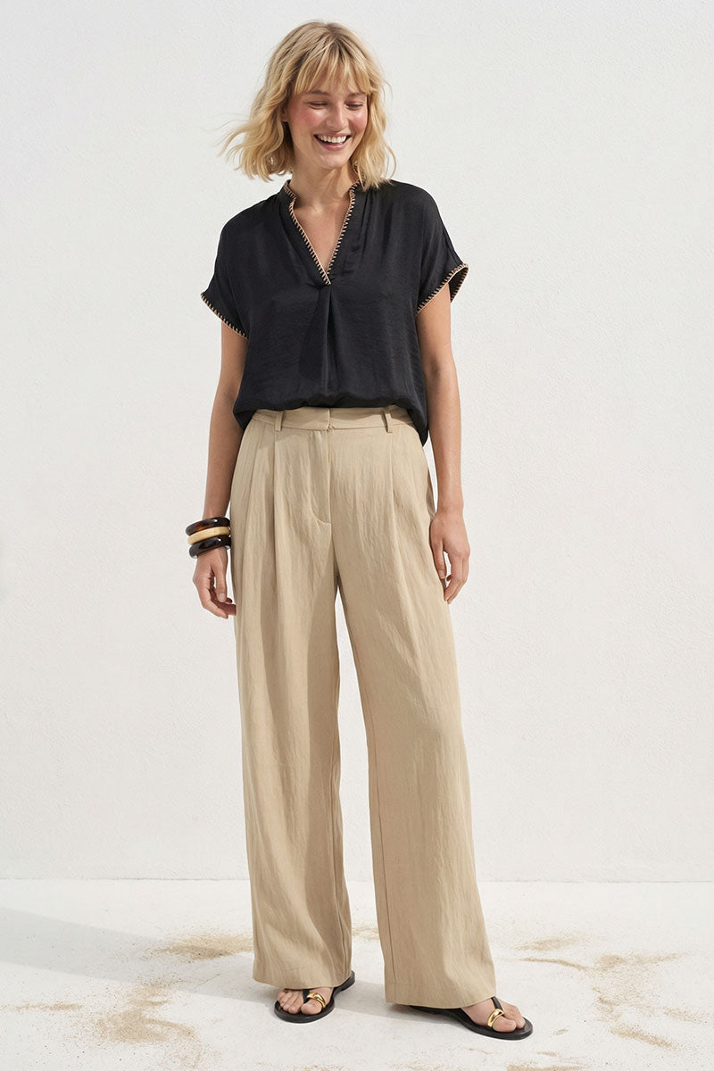 Black V-neck drop-shoulder blouse with whipstitch edging and short sleeves