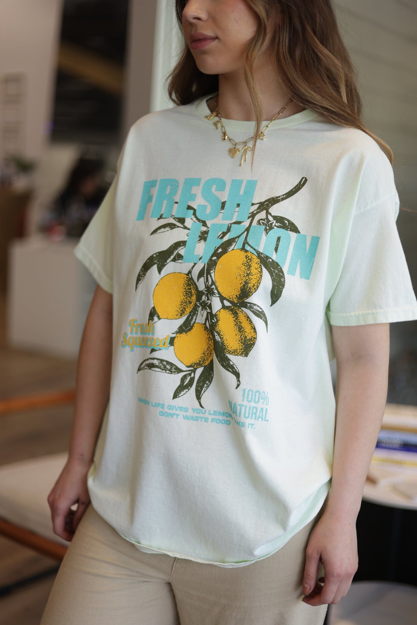 Person wearing a white t-shirt with a lemon graphic and text.