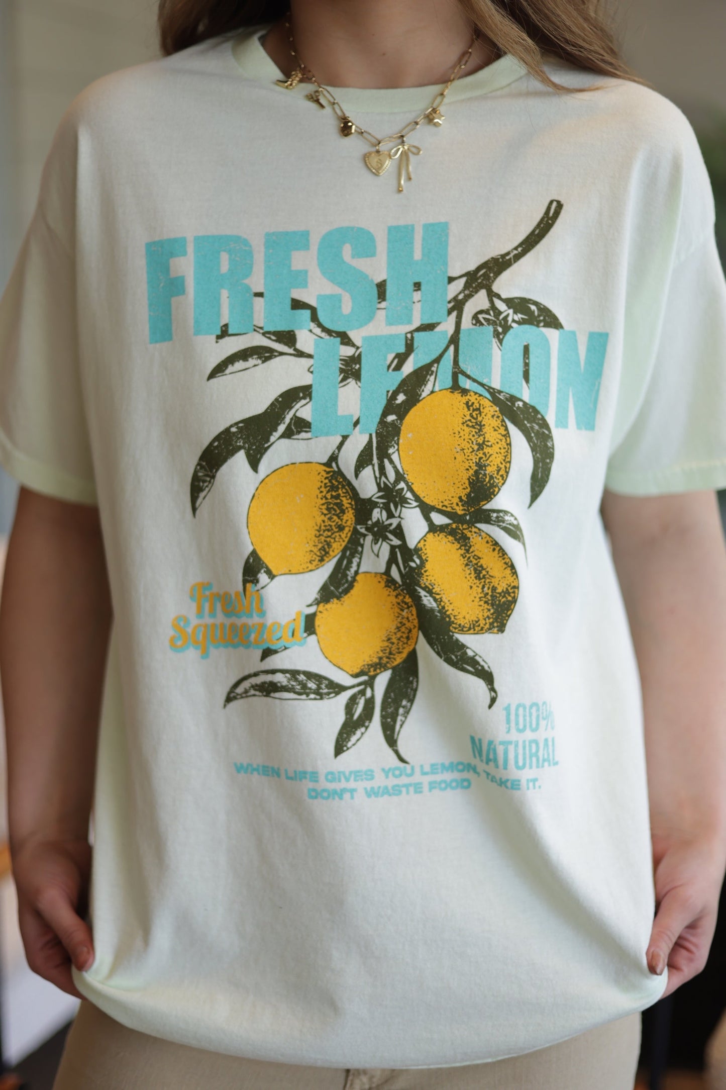 Person wearing a t-shirt with a lemon graphic and text