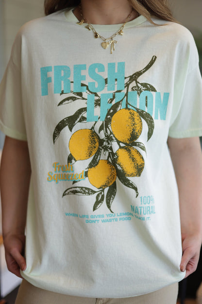 Person wearing a t-shirt with a lemon graphic and text
