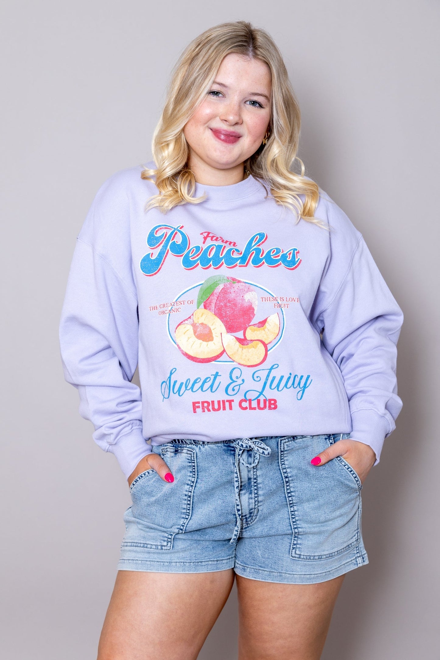 Periwinkle sweatshirt with front peach graphic and slogan Sweet & Juicy Fruit Club