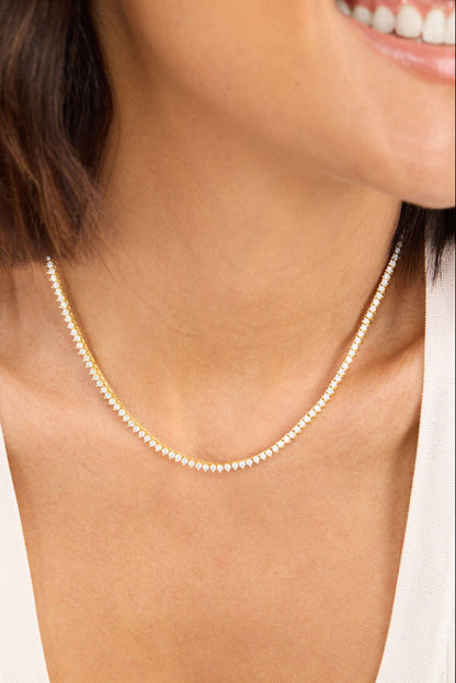 Gold tennis necklace with white pavé stones on collarbone