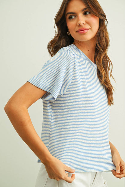 Woman wearing a light blue and white slub striped t-shirt against a plain background