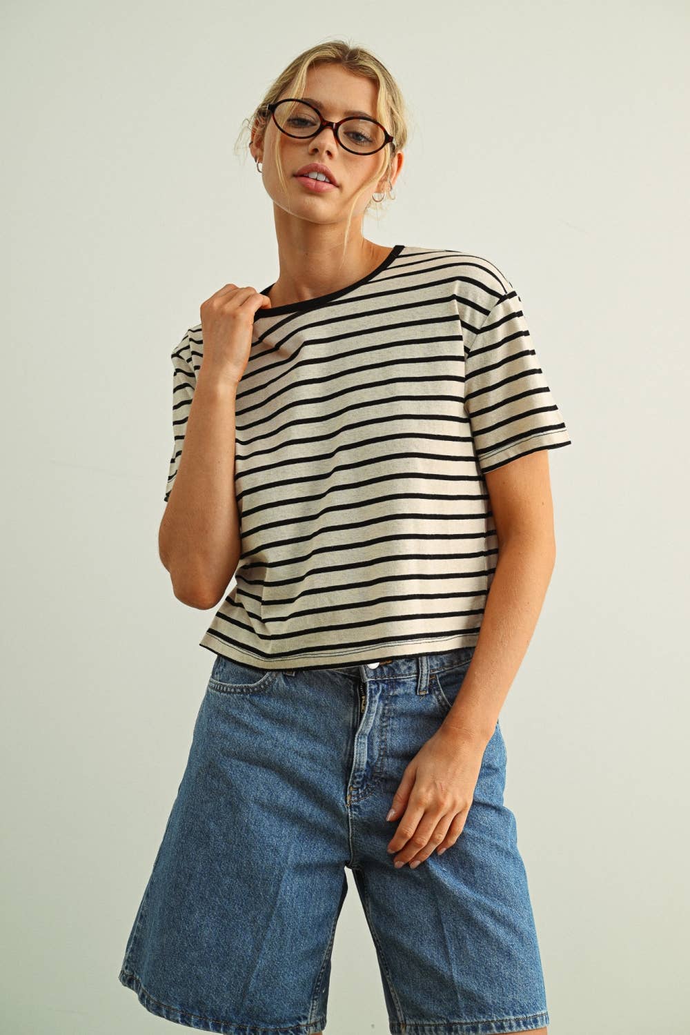 Woman wearing a black striped essential ringer shirt and jeans against a plain background