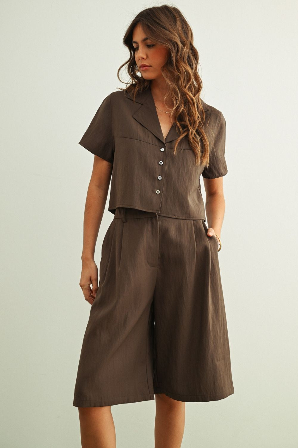 Woman wearing a brown outfit with a plain background