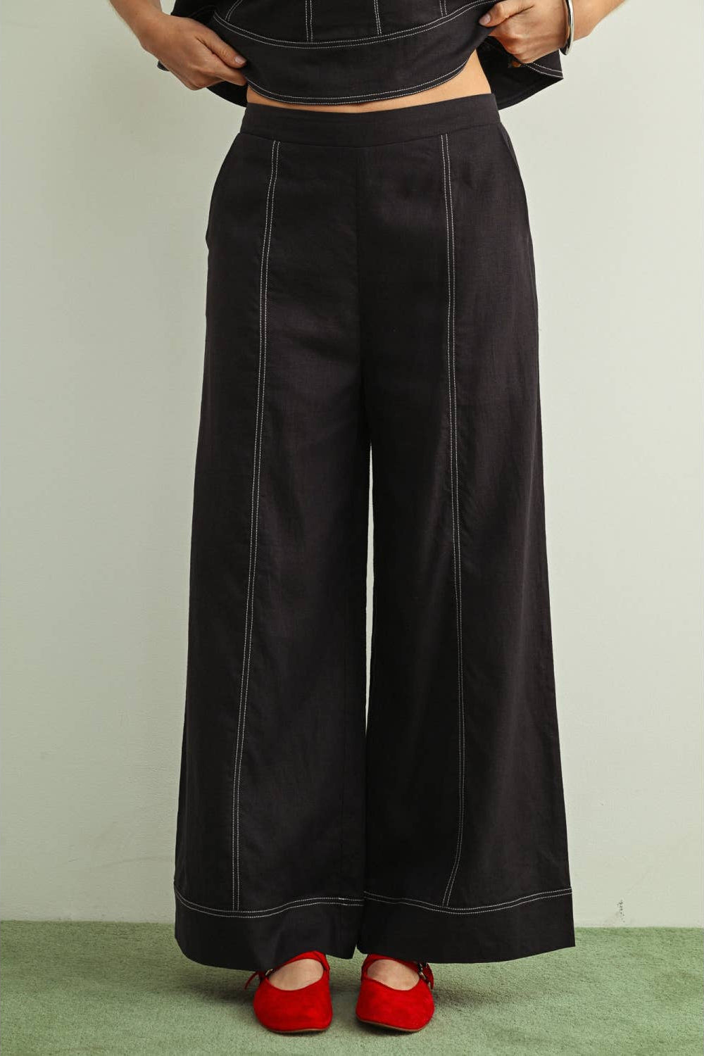 Front view of woman wearing navy wide leg stitched linen pants 