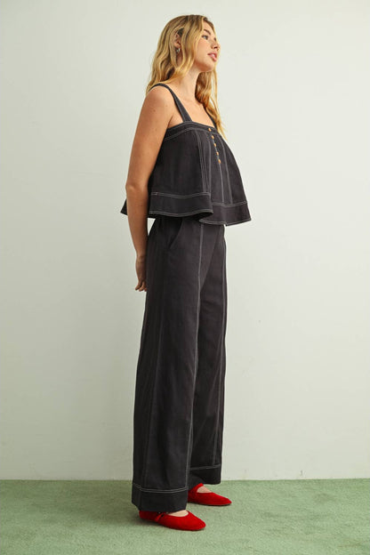 Side view of woman wearing navy wide leg linen pants with a matching navy linen sleeveless top