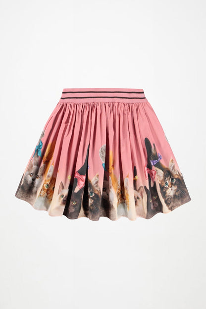 A pink pleated mini skirt featuring a printed pattern of various cat faces around the hem, with a matching pink elastic waistband accented by thin black stripes.