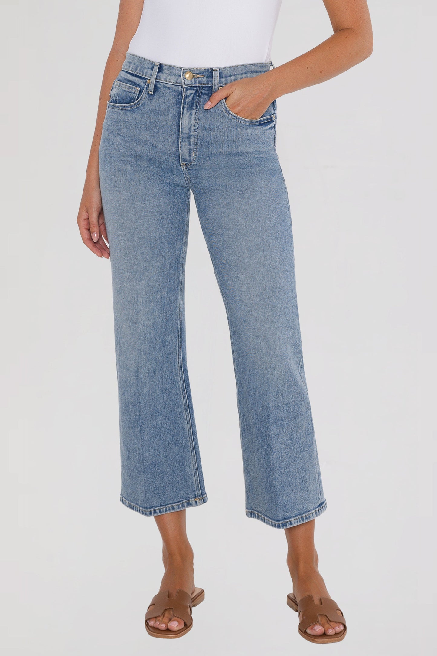 Person wearing light bleu ciel crop jeans on a white background